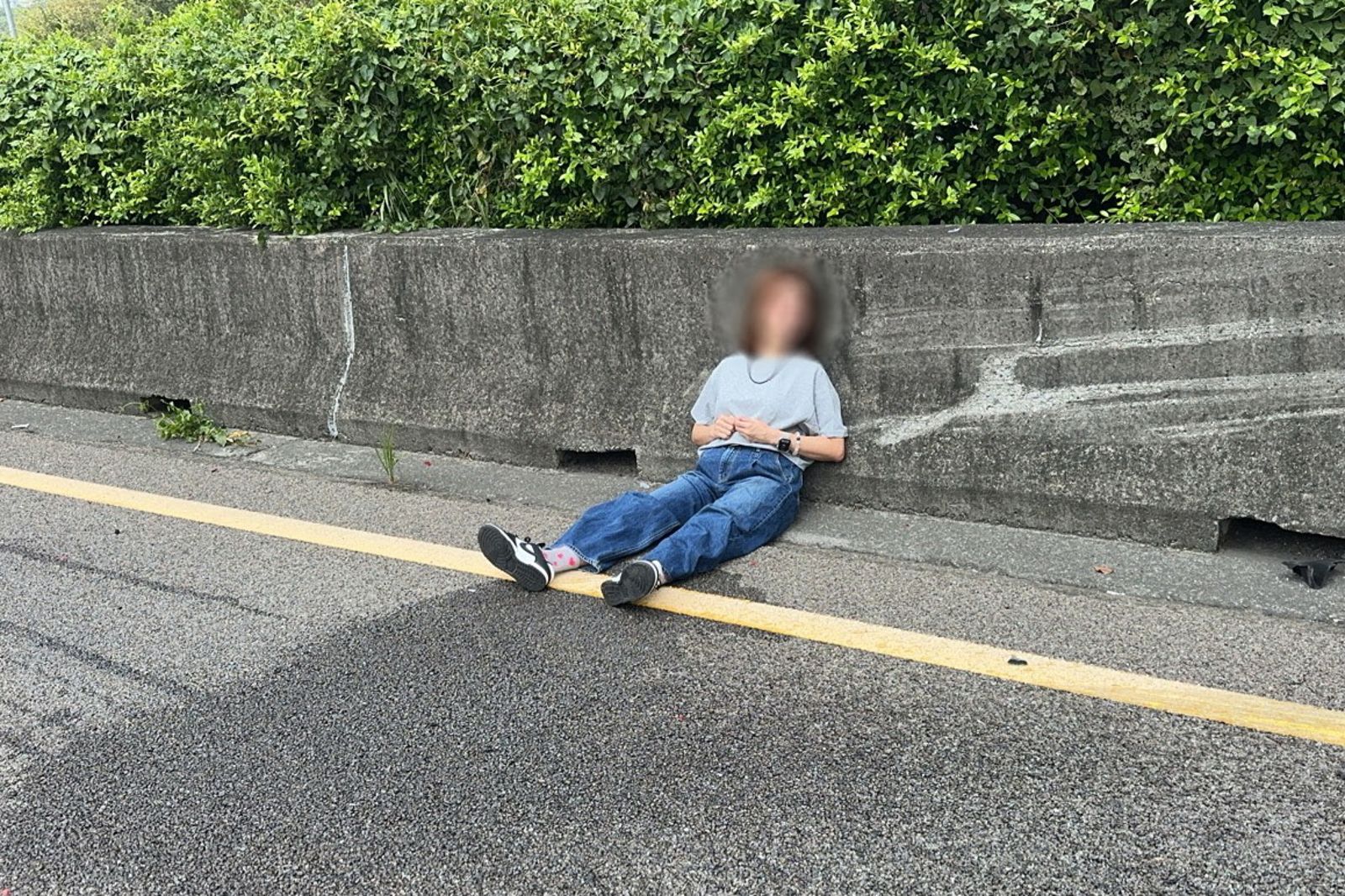 白色VOLVO轎車追撞損毀，駕駛林女受傷坐在分隔島護欄旁，等候警消救援。民眾提供